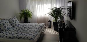 a bedroom with a bed and a window with plants at Apartament I Love Gdynia in Gdynia