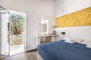 a bedroom with a bed and a desk and a window at I Gelsomini Guest House in Noto