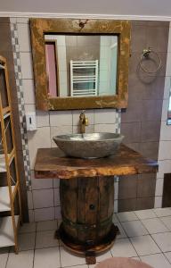 a bathroom with a sink on a wooden table with a mirror at Vila Magnolia in Curtea de Argeş
