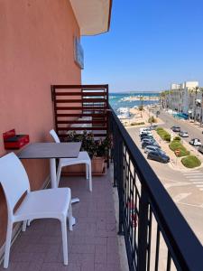 a balcony with a table and chairs and the ocean at Il Vascello in Porto Cesareo