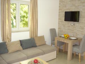 a living room with a couch and a table at Apartments Villa Danilovic in Herceg-Novi