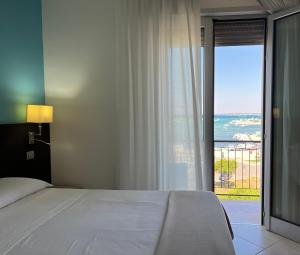 1 dormitorio con cama y vistas al océano en Il Vascello en Porto Cesareo