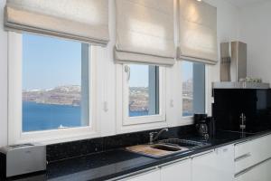 una cucina con due finestre, un lavandino e un bancone di Zen Villas ad Akrotírion
