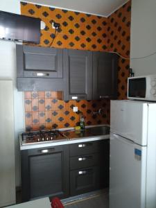 una cucina con armadi grigi e frigorifero bianco di Vicino al Prato della Valle a Padova