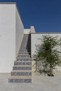 a staircase with blue and white tiles and a tree at I Gelsomini Guest House in Noto