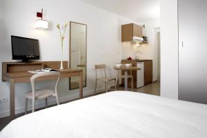 シェルブール・アン・コタンタンにあるAppart'City Confort Cherbourgのベッドルーム1室(ベッド1台、デスク、テレビ付)