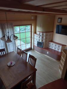 a dining room with a wooden table and a kitchen at Apartmaji Pri Handelčanih, Zreče in Zreče