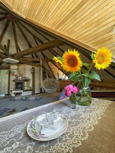 einen Tisch mit einer Vase aus Blumen und einem Teller in der Unterkunft Lavender House in Slawske