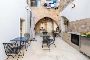 eine Terrasse mit Tischen und Stühlen und eine Küche in der Unterkunft Jozefin in Akkon