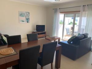 a living room with a dining room table and a couch at Apartamento Nectarina - Cabanas Beach Clube in Cabanas de Tavira