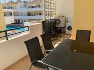 a table and chairs in a room with a balcony at Apartamento Nectarina - Cabanas Beach Clube in Cabanas de Tavira