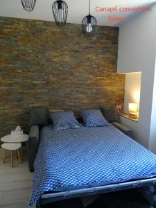 a bedroom with a bed and a brick wall at LOT OF BED in Cahors