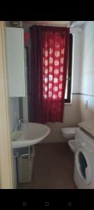 uma casa de banho com um lavatório, um WC e uma cortina vermelha em Villa Medi em Lesina