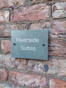 a sign on the side of a brick wall at The York Riverside Suites in York
