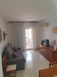 salon z kanapą i telewizorem w obiekcie Schöne Ferienwohnung ca. 350m vom Strand entfernt w mieście Oropesa del Mar