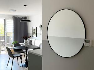 ein Badezimmer mit einem Spiegel und ein Esszimmer mit einem Tisch in der Unterkunft Przestronne apartamenty na Mazurach in Angerburg