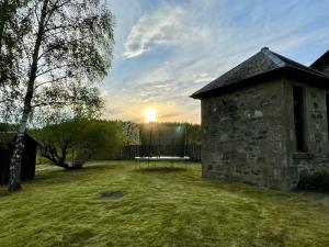 un edificio de piedra con una mesa en un patio en *Cool, cosy cottage in the heart of the Highlands* en Kincraig