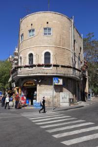 a man crossing a street in front of a building at The White House Jerusalem סוויטת הבית הלבן ירושלים in Jerusalem