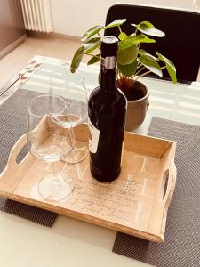 a bottle of wine and two glasses on a table at Denis Apartament in Turda