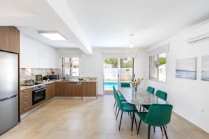 a kitchen and dining room with a table and chairs at Villa Lantos Central Protaras in Protaras