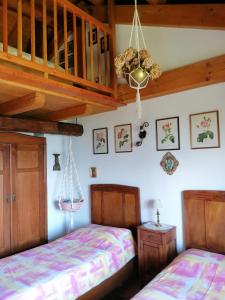 a bedroom with two beds and a staircase at Baita Agaz in Sovramonte