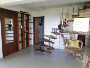 ein Wohnzimmer mit einer Holztreppe und einem Stuhl in der Unterkunft Charly's place in Calibishie