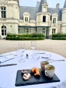 una mesa con un plato de comida y copas de vino en Château le Fresne, en Bouchemaine