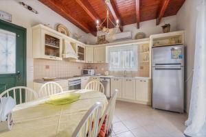 a kitchen with a table and a refrigerator at MARFAIA - Villa by the sea in Áyioi
