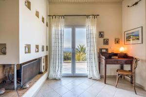 uma sala de estar com uma secretária e uma porta de vidro deslizante em MARFAIA - Villa by the sea em Áyioi