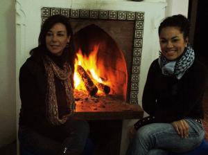 two women are sitting in front of a fireplace at Hotel Dar Mounir in Chefchaouen