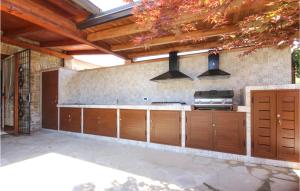 an outdoor kitchen with wooden cabinets and a stove at 6 Bedroom Beautiful Home In Perdifumo in Perdifumo