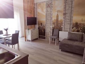ein Wohnzimmer mit einem Sofa und einem TV in der Unterkunft Ferienwohnung Lavanda in Rust