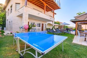 a ping pong table in the backyard of a house at Rom Mansion in Rosh Pinna