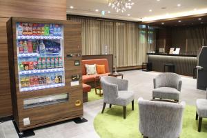 uma sala de espera com cadeiras e uma máquina de refrigerantes em Almont Hotel Sendai em Sendai