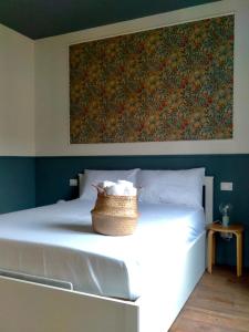 a bedroom with a white bed with a basket on it at Ripa Apartments Milano - Vigevano in Milan