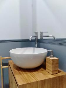 ein weißes Spülbecken auf einer Holztheke im Bad in der Unterkunft Ripa Apartments Milano - Vigevano in Mailand