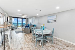 a kitchen and living room with a table and chairs at Updated Beachfront 2 BR 2 Bath Condo with direct views of the beach in Orange Beach