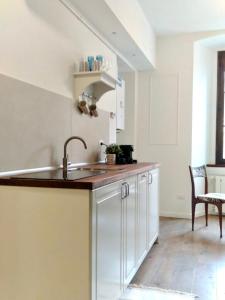 a kitchen with white cabinets and a sink at Ripa Apartments Milano - Vigevano in Milan