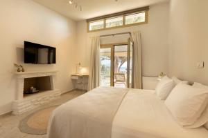 a white bedroom with a bed and a fireplace at Villa Aura Loutraki in Loutraki +45 photos