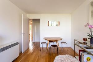 a kitchen and dining room with a table and stools at Modern Victoria Park Apartment in London