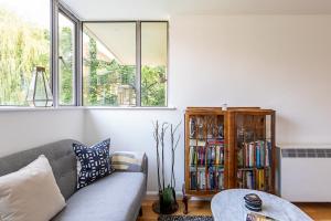 a living room with a couch and a book shelf at Modern Victoria Park Apartment in London