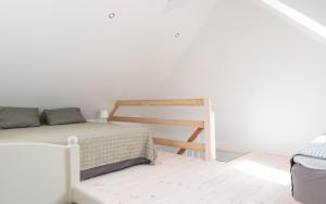 a white bedroom with a bed and a ladder at Ferielejlighed Næstved in Næstved
