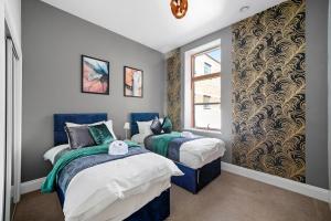 1 dormitorio con 2 camas y ventana en Stunning Abode - Sleeps 10 - Parking, en Bristol