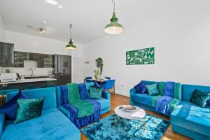 una sala de estar con sofás azules y una mesa. en Stunning Abode - Sleeps 10 - Parking, en Bristol