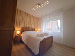 een slaapkamer met een bed met twee handdoeken erop bij Fête des jonquilles in Gérardmer