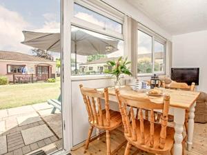 a dining room with a table and an umbrella at Dawlish Warren Holidays in Dawlish