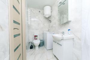 een witte badkamer met een toilet en een wastafel bij Cozy SmartHouse in Kiev