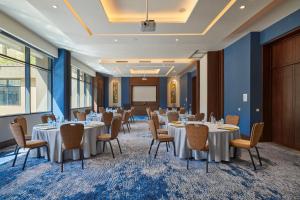 uma sala de conferências com mesas e cadeiras e um ecrã de projecção em Crowne Plaza - West Cairo Arkan, an IHG Hotel em Cidade 6 de Outubro