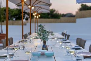 una mesa larga con copas y una botella de vino en Villa Aura Loutraki, en Loutraki