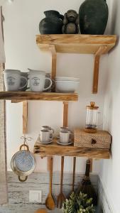 un grupo de estanterías de madera con tazones y tazas en Linari Bohemian Living, en Kávallos